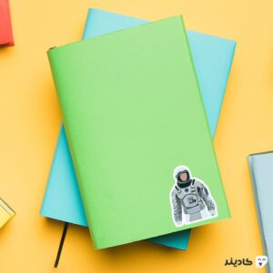 استیکر لپ تاپ کوپر فضانورد روی دفترچه