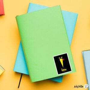 استیکر لپ تاپ پوستر لباس گادفادر رنگ زرد روی دفترچه