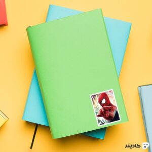 استیکر لپ تاپ پوستری از مرد عنکبوتی روی دفترچه