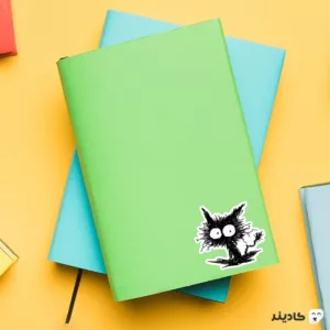 استیکر لپ تاپ سیاه و سفید - گربه روی دفترچه